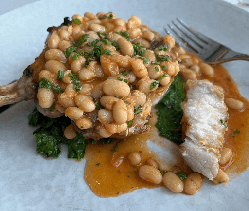 Pork chop, cassoulet, and garlic rapini.